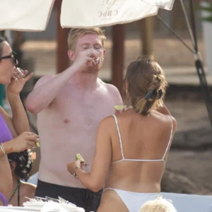 Kevin De Bruyne and Michele Lacroix knocked back a shot at a beach club